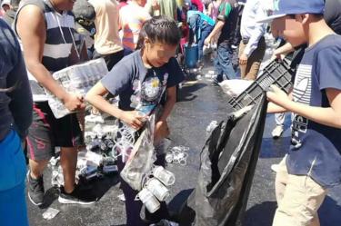 Hombres, mujeres y niños rapiñan cerveza de tráiler volcado