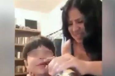 La mujer le enseña a tomar y fumar a su hijo. Foto: Especial