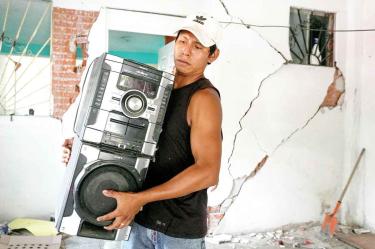 SALVANDO PERTENENCIAS. En Huatulco, Oaxaca, un habitante saca sus pertenencias, entre ellas un estéreo, con el fin de ponerlas a salvo ya que su vivienda quedó seriamente dañada a causa del pasado sismo del martes.