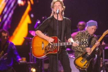 Mick Jagger con guitarra y cantando durante una presentación de The Rolling Stones