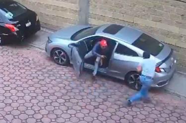 Ladrón de autos apunta con su arma al dueño del carro