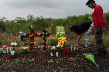 Local residents place candles to mourn for the victims at the scene where dozens of migrants were found dead inside a trailer truck in San Antonio, Texas.