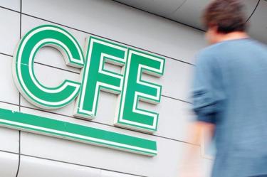 Un hombre observa Logotipo de CFE