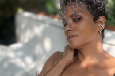 Halle Berry agarrándose el cuello con blusa de encaje color negra