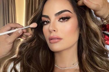 Ximena Navarrete de perfil con manos maquillándole el rostro