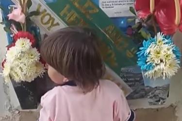 Niño visita la tumba de su papá