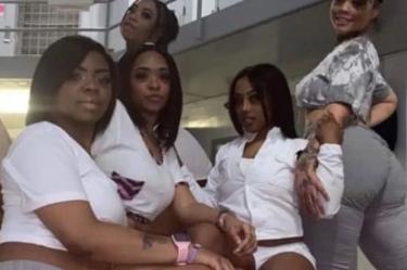 Mujeres posando con uniformes de prisioneras en cárcel
