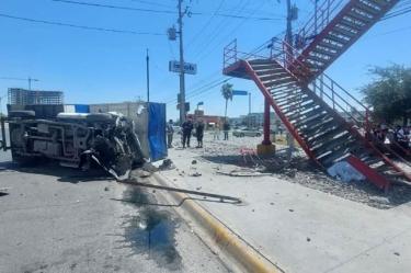 Camioneta volcada a un lado de un puente peatonal