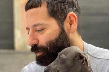 Director creativo de Moschino, Davide Renne, de perfil cargando perro