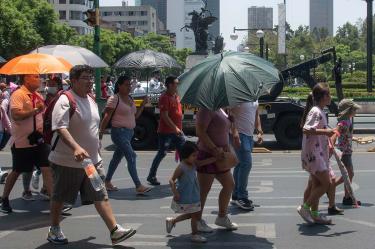 Personas se protegen del calor en calles de México
