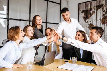 Trabajadores chocan las manos en una reunión