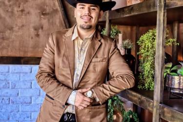 Adrián Quintanilla con sombrero y chamarra café