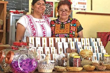 Iris Carrasco (der.) y su hija Iris López resguardan una receta artesanal del chocolate creada en 1920 y para la cual utilizan metate.