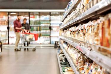 Una pareja comprando abarrotes en un supermercado.