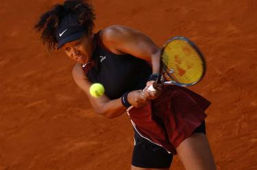 Naomi Osaka golpeando la pelota a dos manos.