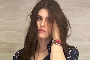 Alexandra Daddario con blusa negro, cabello en rostro