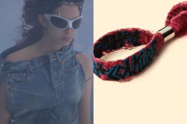 Modelo con lentes y chamarra de mezclilla y brazalete de Balenciaga