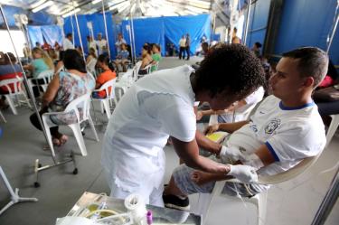 Centro de atención temporal en Brasil durante un brote de chikungunya, donde un enfermero proporciona tratamiento a un paciente. La imagen resalta la respuesta sanitaria ante la alta incidencia de enfermedades transmitidas por mosquitos.
