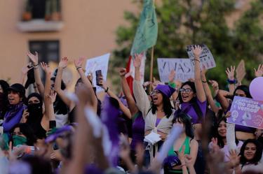Mujeres durante una marcha femenina donde todas usan ropa color morado