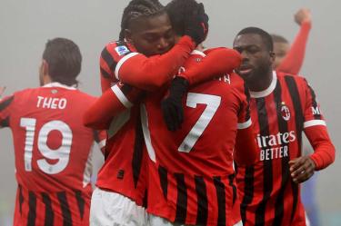Jugadores del AC Milán celebrando abrazados.
