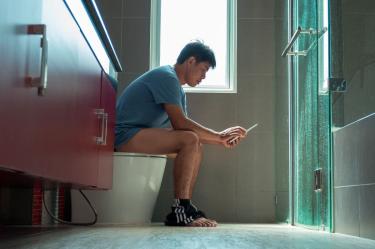 El uso del móvil en el baño incrementa el riesgo de hemorroides. Foto: Canva.