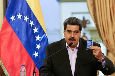 El presidente de Venezuela, Nicolás Maduro, sostiene una copia de la constitución venezolana mientras habla durante una reunión con miembros del cuerpo diplomático venezolano después de su llegada de Estados Unidos.