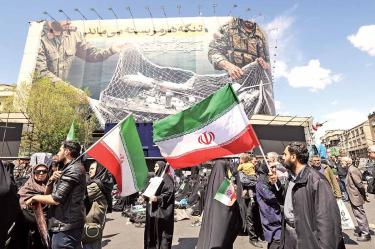 Iraníes ondean banderas de su país frente al anuncio: El estrecho de Ormuz permanece cerrado.