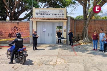 Entrada de la Secundaria Técnica Número 18 en Ciudad Chapultepec, Cuernavaca, con padres de familia aglomerados tras la suspensión de clases por un estudiante armado.