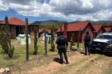 Elementos de la Policía Estatal resguardan cabañas en Durango tras el hallazgo sin vida de un joven originario de Estados Unidos.