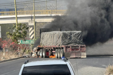 Tráiler incendiado sobre la carretera Colima-Manzanillo en Tecomán durante un operativo de seguridad tras un enfrentamiento.