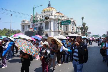 Maestros de la CNTE con sombrillas marchan hacia la Secretaría de Gobernación