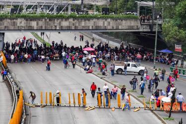 Manifestantes del magisterio bloqueando el tránsito vehicular en Circuito Interior, Ciudad de México, causando intenso tráfico.