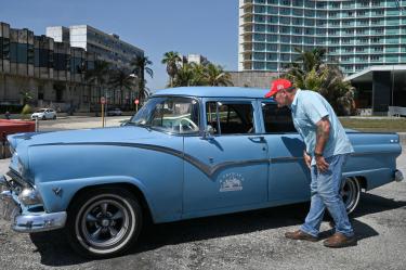 Vic Mellor, empresario estadounidense y candidato republicano, observa un automóvil clásico estacionado en una calle de La Habana.