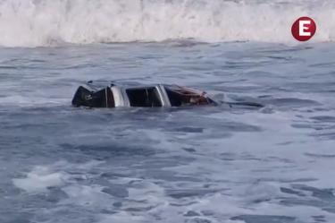 Una camioneta pick-up blanca flotando a la deriva en las aguas turbulentas del mar de fondo en la playa de Boca de Pascuales, Tecomán, Colima.