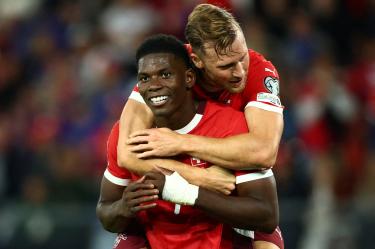 Breel Embolo celebra un gol cargando a Silvan Widmer.