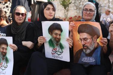 Mujeres iraníes sostienen retratos de Mojtaba Jamenei.