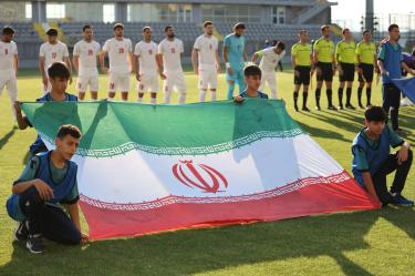 La selección de Irán detrás de su bandera previo a un partido.