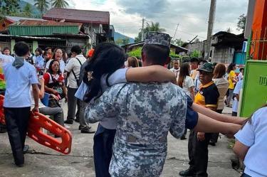 Integrante de la guardia costera de Filipinas ayuda a una persona tras terremoto magnitud 7.8.