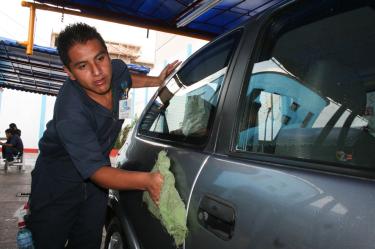 MÉXICO, D.F., 25JULIO2008.- Victor Reyes, es un lava coches de Lindavista que trabaja en un establecimiento serio, recibe propinas por cada uno que seca y almorolea, a diferencia de los lava coches de las calle o franeleros, Victor recibe un sueldo por sus servicios, es dura la chamba pero no me va tan mal comenta mientras seca la puerta de un auto. FOTO: RICARDO CASTELAN /CUARTOSCURO.COM