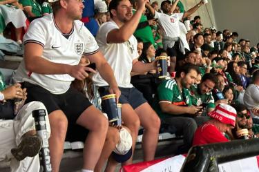 Dos aficionados ingleses se robaron las miradas al bailar en medio de una tribuna repleta de seguidores de la Selección Mexicana, durante la espera por el inicio del partido amenizada por el sonido local.
