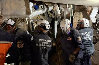 This handout image released by the Miami Fire-Rescue Department shows rescuers working inside a collapsed building as they attempt to reach Hernan Gil, who survived for nearly eight days beneath the rubble of a building on the verge of collapse in Catia La Mar, La Guaira state, Venezuela on July 2, 2026, after the June 24 twin earthquakes. Gil was rescued on July 2, 2026 through a tunnel roughly three meters long dug by rescue workers from seven countries, who had worked tirelessly, supplying him with water and air via probes and a hose. (Photo by Handout / City of Miami Fire-Rescue / AFP) / RESTRICTED TO EDITORIAL USE - MANDATORY CREDIT "AFP PHOTO / Miami Fire-Rescue Department" - NO MARKETING NO ADVERTISING CAMPAIGNS - DISTRIBUTED AS A SERVICE TO CLIENTS