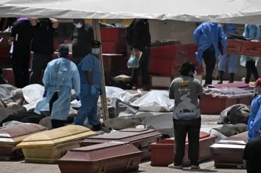 Forenses entre víctimas y ataúdes en el puerto de La Guaira