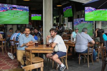CIUDAD DE MÉXICO, 22JUNIO2026.- Aficionados de diversas nacionalidades observan el primer tiempo del partido entre las selecciones de Francia e Irak, correspondiente a la Copa Mundial de la FIFA 2026, en restaurantes de la colonia Roma. Al llegar el medio tiempo, el encuentro fue suspendido debido a las condiciones climatológicas, con marcador de 1-0 a favor de Francia.FOTO: CAMILA AYALA BENABIB / CUARTOSCURO.COM