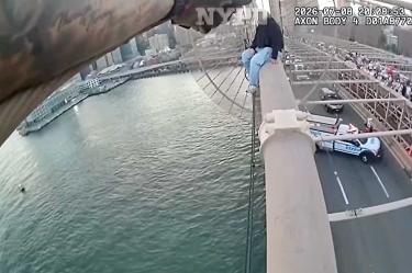 Mujer y policía en las alturas del puente de Brooklyn, durante rescate.
