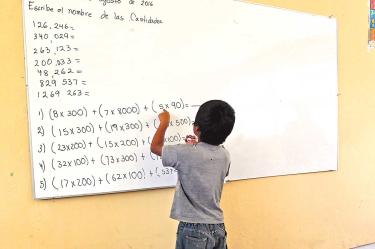 Un alumno de educación básica resolviendo un ejercicio en un pizarrón.