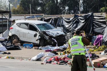 Un miembro de Carabineros trabaja junto a un vehículo que atropelló a varias personas en un mercado callejero de Viña del Mar