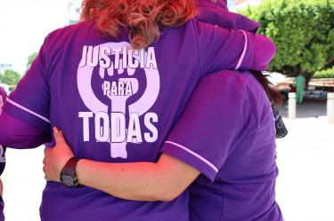 Manifestantes feministas con camisetas moradas con el lema 'JUSTICIA PARA TODAS' se abrazan en México. Imagen de solidaridad y activismo contra el feminicidio, vinculada al caso de Karla Velasco
