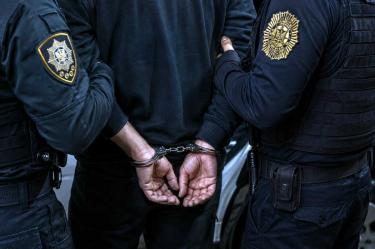 Un policía de la CDMX con esposas y detenido.