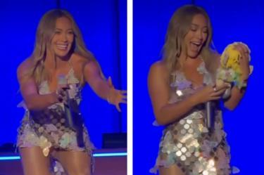 Hilary Duff recibe un pelcuche Dr. Simi con su vestido de estrellas durante un concierto