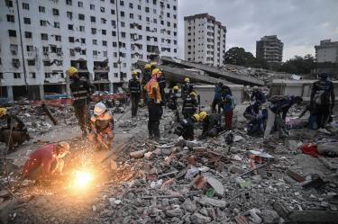 Voluntarios y equipos de rescate buscan cuerpos entre los escombros de edificios dañados por los terremotos del 24 de junio en Tanaguarena, estado de La Guaira.